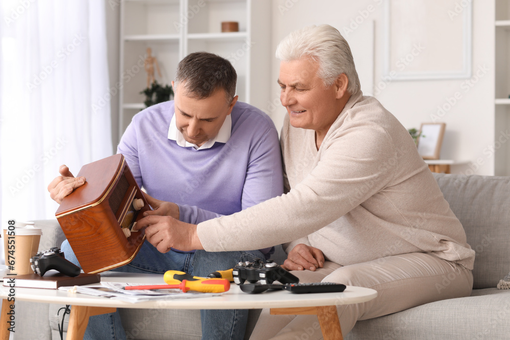 Mature brothers with retro radio receiver at home Mature brothers with retro radio receiver at home
