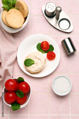 Plate of tasty crouton with cream cheese and fresh tomatoes on pink tile background