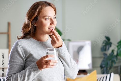 Young woman taking medication at home