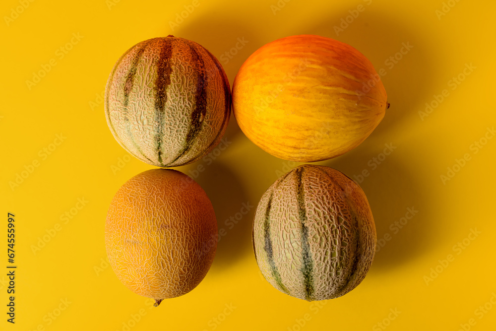 Different sweet melons on yellow background Different sweet melons on yellow background