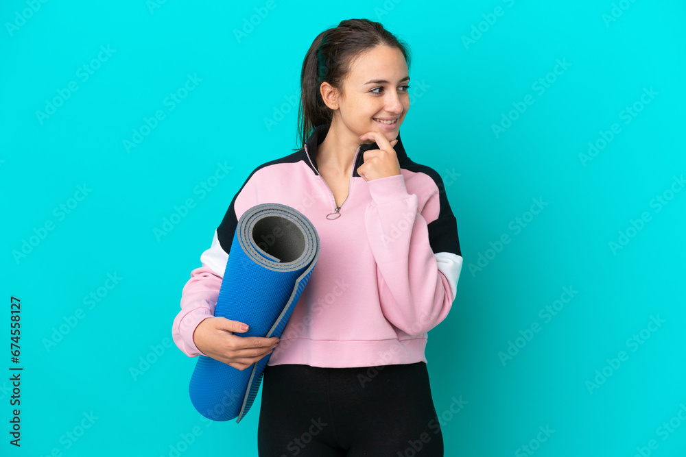 Sport Ukrainian woman going to yoga classes while holding a mat looking to the side and smiling Sport Ukrainian woman going to yoga classes while holding a mat looking to the side and smiling