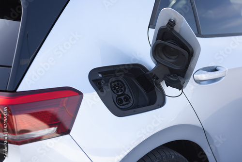 Type 2 CCS plug port on electric vehicle. DC - CCS type 2 EV charging connector at EV car. Fast charging socket type 2 combo electric car. Eco friendly alternative energy green environment concept photo