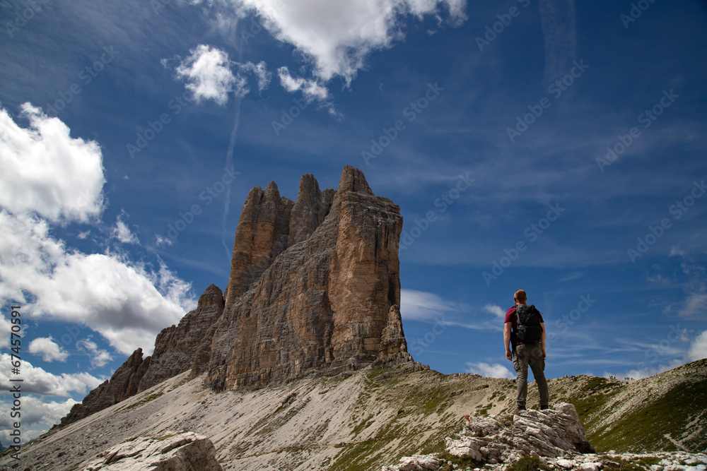 Stunning view of a tourist enjoying the view of the Tre Cime Di Lavaredo, Dolomites, Italy.