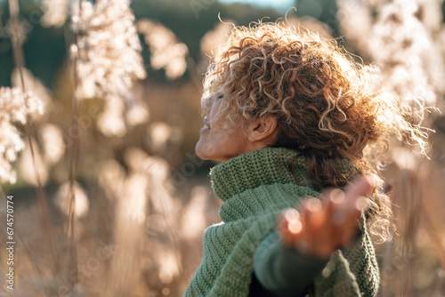 Schilderij op canvas Happy healthy free woman outstretching arms in outdoor leisure activity alone kissed by golden sun sunlight sunset light