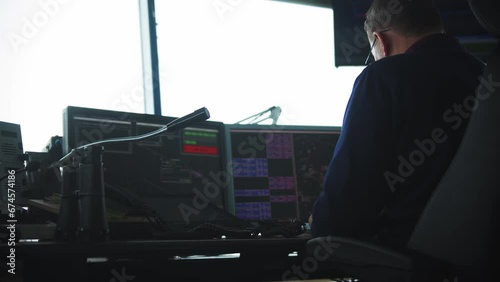 Navigation control room in the airport - a man working with a monitor with fly paths placed on the map photo