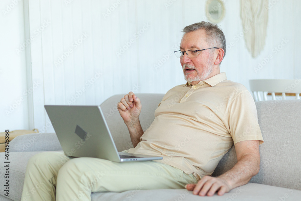 Happy middle aged senior man with laptop talk on video call with friends family. Mature old senior grandfather having fun talking with grown up children online. Older generation modern tech usage Happy middle aged senior man with laptop talk on video call with friends family. Mature old senior grandfather having fun talking with grown up children online. Older generation modern tech usage