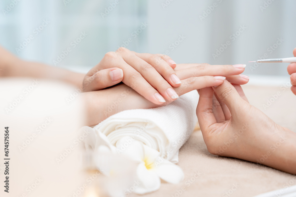 Naklejka premium Woman receive care service by professional Beautician Manicure at spa centre. Nail beauty salon use nail file for Glazing treatment. manicurist make nail customer to beautiful. body care spa treatment