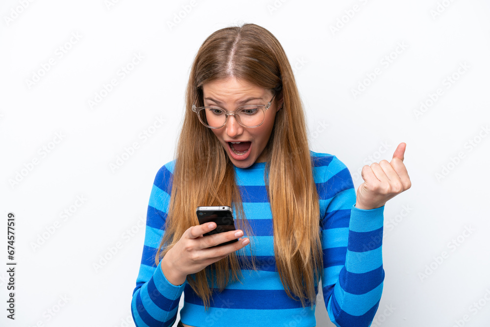 Young caucasian woman isolated on white background surprised and sending a message Young caucasian woman isolated on white background surprised and sending a message