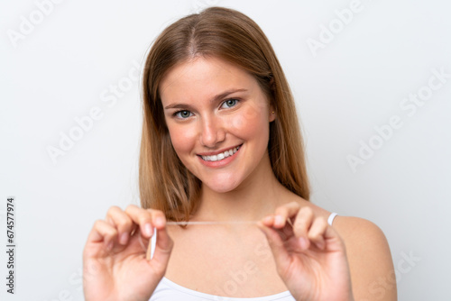 Young caucasian woman isolated on white background with dental floss. Close up portrait