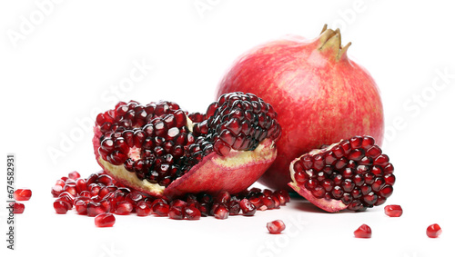 Several ripe pomegranate fruits and an open whole pomegranate, Juicy pomegranate seeds on table, Fresh ripe Pomegranate half isolated on white background, Healthy pomegranates fruit garnet, side view