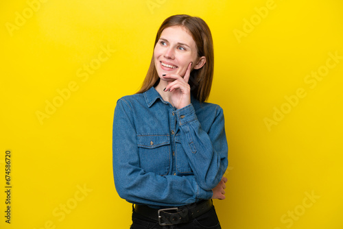 Young English woman isolated on yellow background thinking an idea while looking up