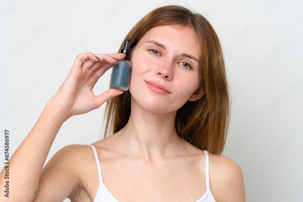 Obraz premium Young English woman holding a serum while smiling. Close up portrait