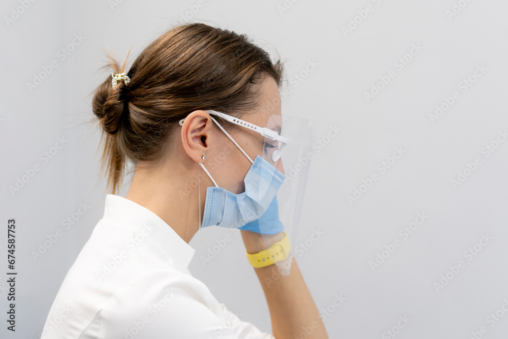young female dentist putting on safety glasses or mask in her cabinet young female dentist putting on safety glasses or mask in her cabinet