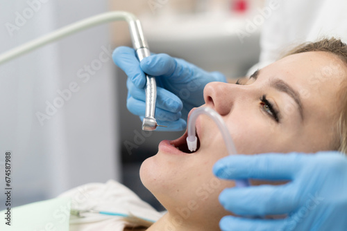dentist doctor treats a patient's teeth, uses a drill to drill a tooth