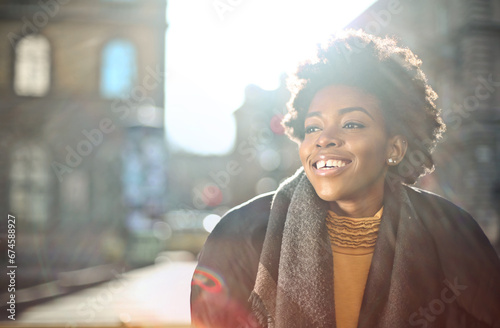 portrait of smiling young black woman in the street