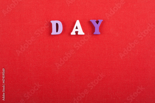 DAY word on red background composed from colorful abc alphabet block wooden letters, copy space for ad text. Learning english concept.
