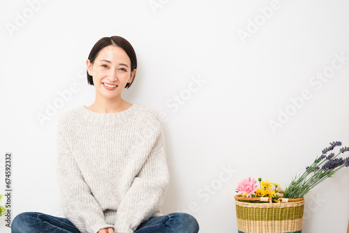 壁にもたれかかって座る若い女性　ライフスタイルイメージ photo