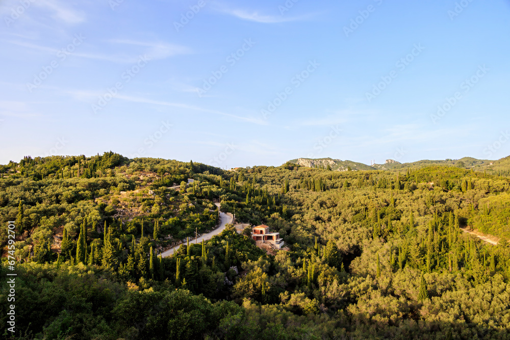View in the evening under a blue sky over the hills and the forest near Paleokastrtitsa on the island of Corfu
