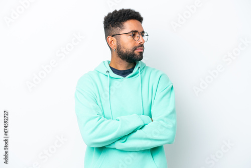 Young Brazilian man isolated on white background keeping the arms crossed