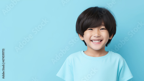 Asian child boy, bowl-cut black hair, pale blue studio