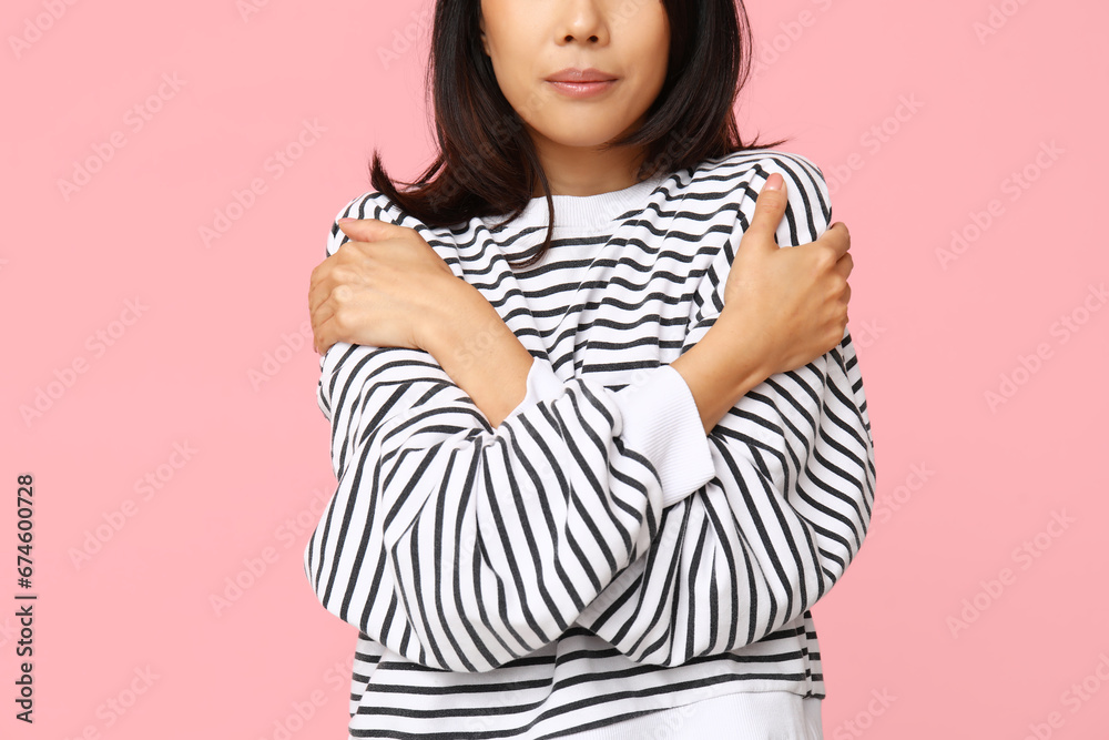 Young woman hugging herself on pink background, closeup Young woman hugging herself on pink background, closeup