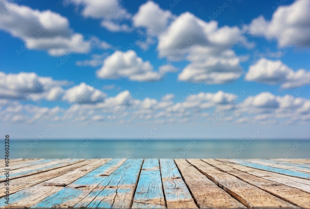Wooden plank with blurred sea and blue cloudy sky