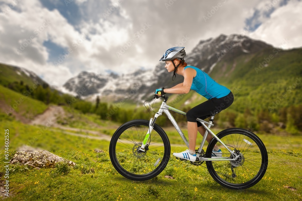 A woman ride on a mountain bike in beautiful nature.