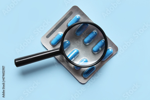 Magnifier with pills on blu...