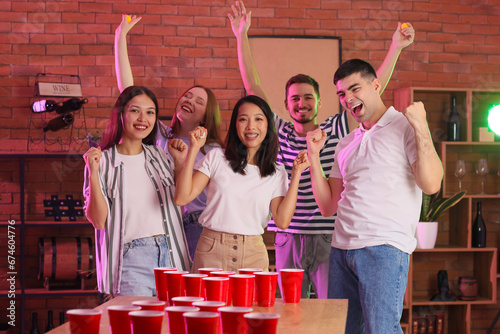 Photography Group of young friends playing beer pong at party