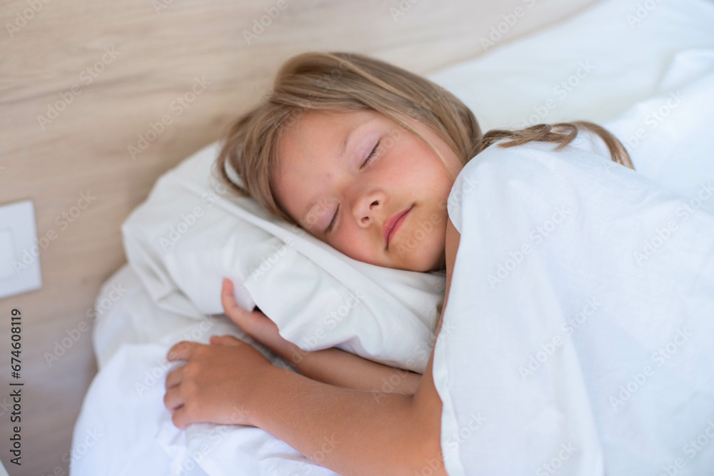 A little girl with long hair is peacefully sleeping in a comfortable bed on a white pillow at the morning. Side Close up shot.It's perfect for projects related to family, childhood, or relaxation. A little girl with long hair is peacefully sleeping in a comfortable bed on a white pillow at the morning. Side Close up shot.It's perfect for projects related to family, childhood, or relaxation.