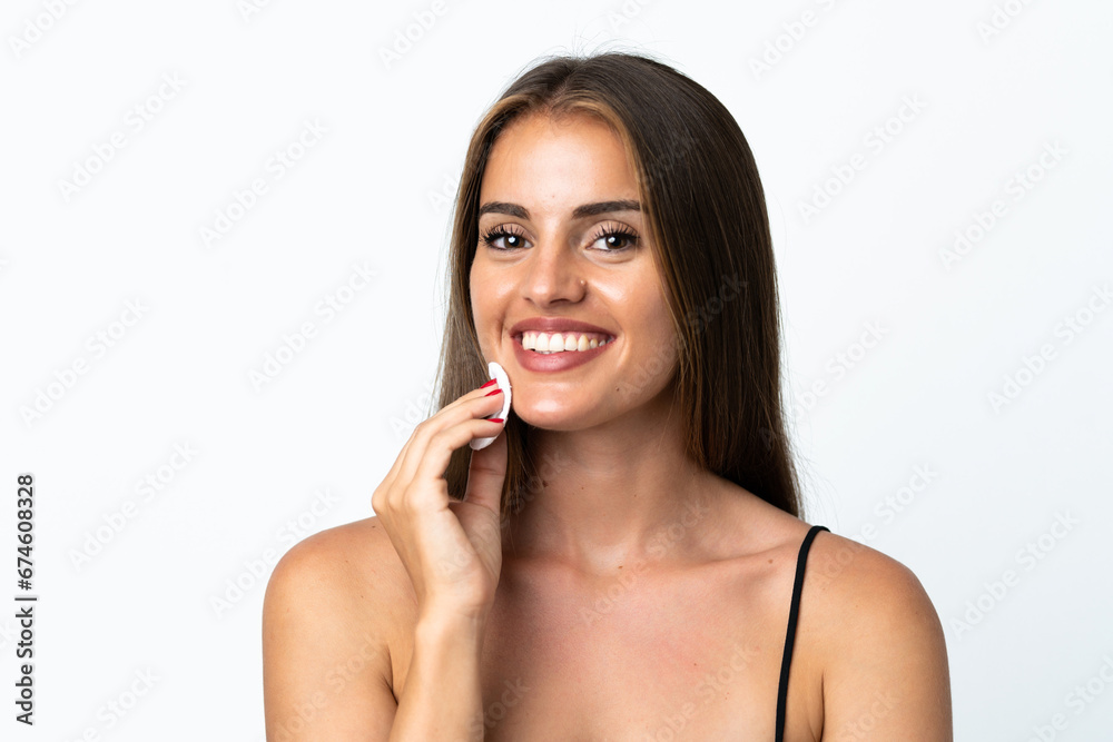 Young Uruguayan woman isolated on white background with cotton pad for removing makeup from her face Young Uruguayan woman isolated on white background with cotton pad for removing makeup from her face