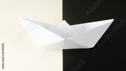  a white paper boat lies on a black-and-white background