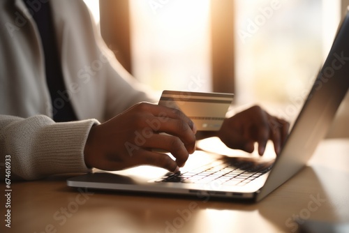 An individual seen from behind  holding a credit card while making an online payment