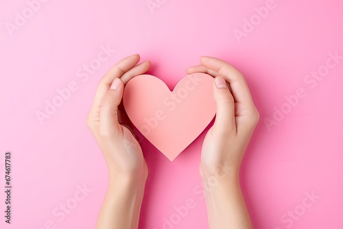 Female hands holding paper heart on pink background. Top view with copy space. Ai generative