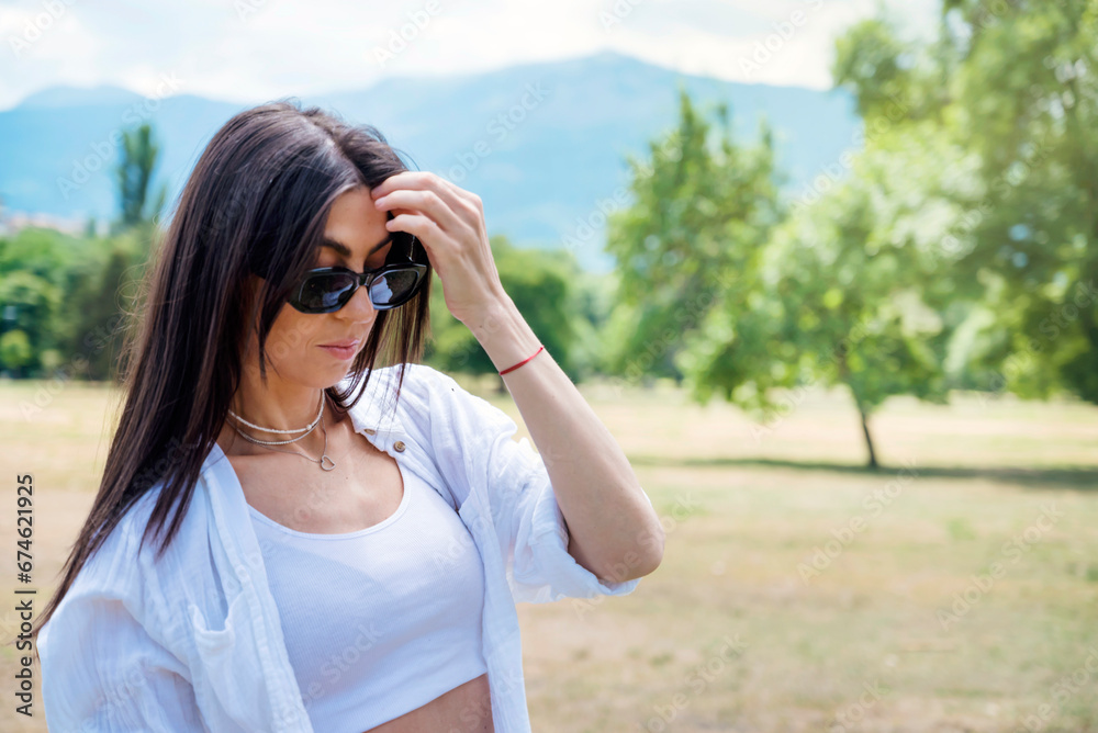 Beautiful brunette woman wearing sunglasses in the summer