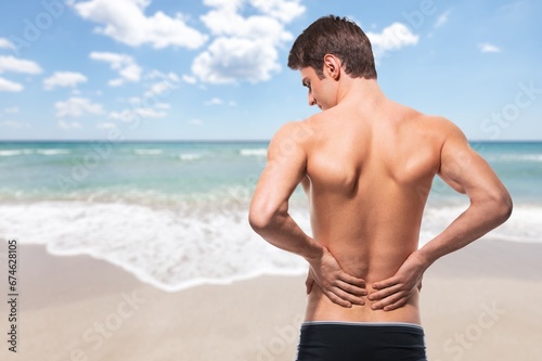 Portrait of handsome young sporty man on the beach