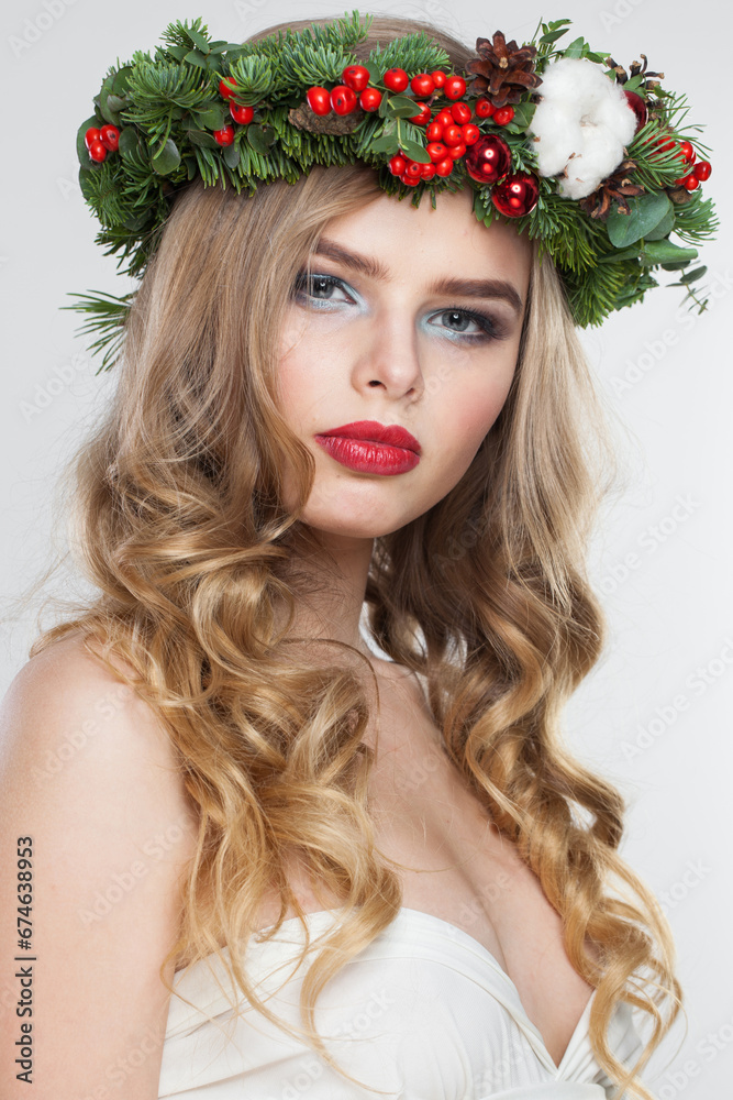 Naklejka premium Perfect blonde woman portrait. Fashion female model with blond curly hairstyle, make-up and green and red winter accessories posing on white background
