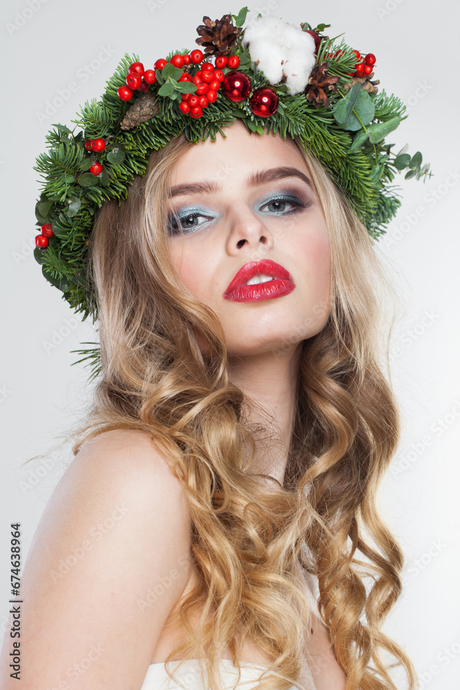 Fashionable model woman with long wavy hair, makeup and colorful natural winter decoration on white studio wall background, fashion beauty portrait Fashionable model woman with long wavy hair, makeup and colorful natural winter decoration on white studio wall background, fashion beauty portrait