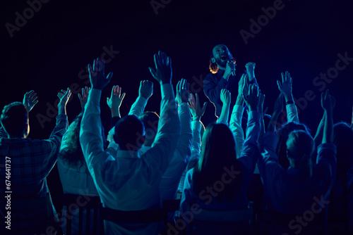 Group of of different people attending concert, stand up show, cheerfully spending time with jokes and funny stories. Applauding. Concept of entertainment, fun and joy, concert, performance