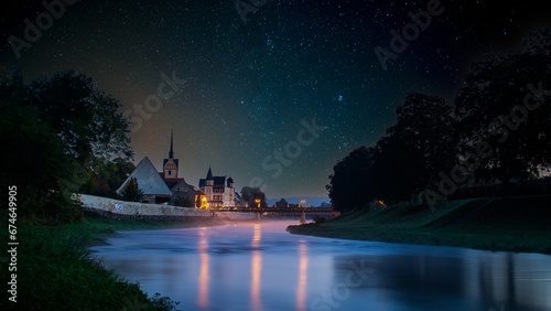 Tranquil night sky reflects illuminated constellations and auroras.