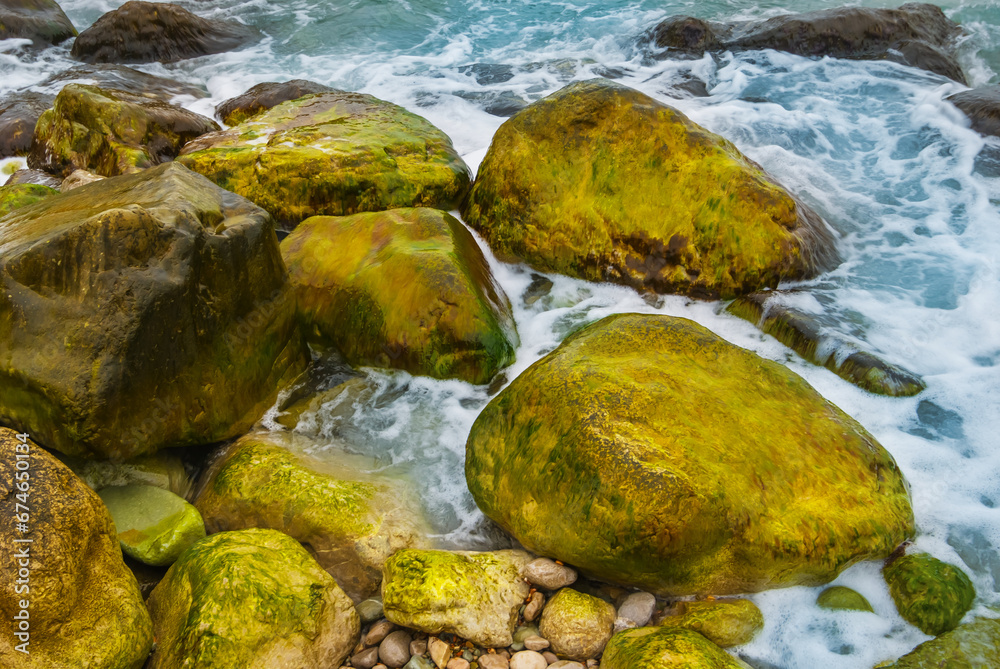 closeup heap of stones on emerald sea coast