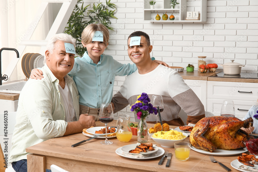 Happy family playing word guessing game at festive table on Thanksgiving Day Happy family playing word guessing game at festive table on Thanksgiving Day