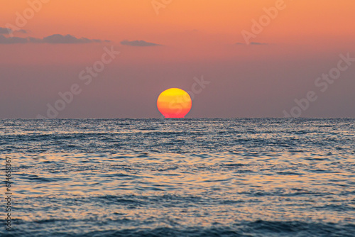 Sunset touching the sea horizon