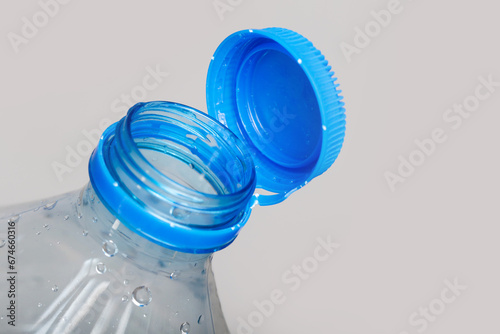 Close up of new cap attached to plastic bottle, connected to the neck of the bottle by solid tab attached to safety ring. They are intended to encourage recycling, as part of the fight against litter. photo