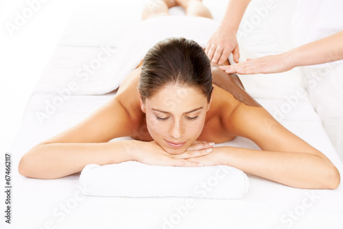 Happy woman, relax and mud massage for zen or mental wellness on bed at luxury resort or salon. Calm female person or model smile for body therapy, beauty treatment or stress relief