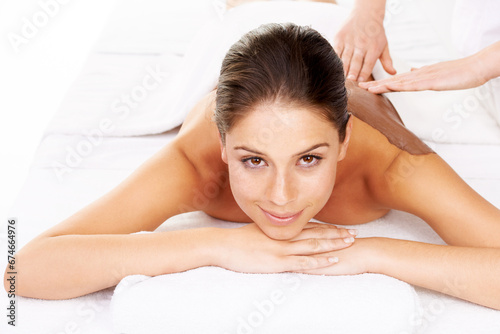 Happy woman, portrait and relax for mud massage, spa or zen on bed at luxury resort or salon. Attractive or calm female person or model smile for body therapy, beauty treatment or stress relief