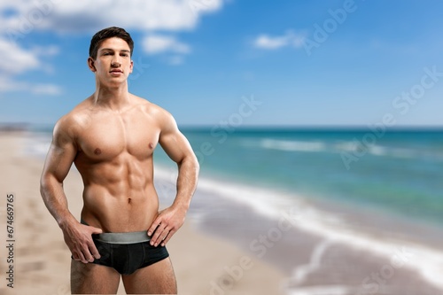Portrait of handsome young sporty man on the beach
