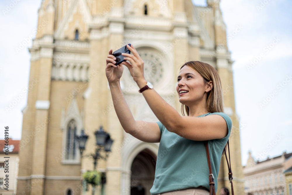 Shot of a young woman taking a selfie on her cellphone while out in the city.