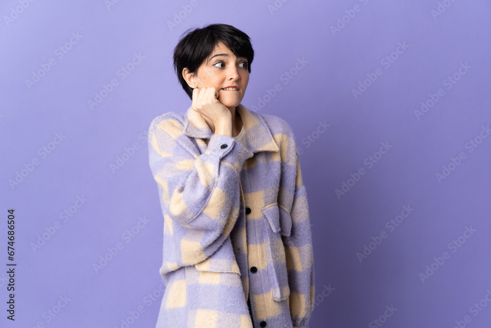Woman with short hair isolated on purple background is a little bit nervous Woman with short hair isolated on purple background is a little bit nervous