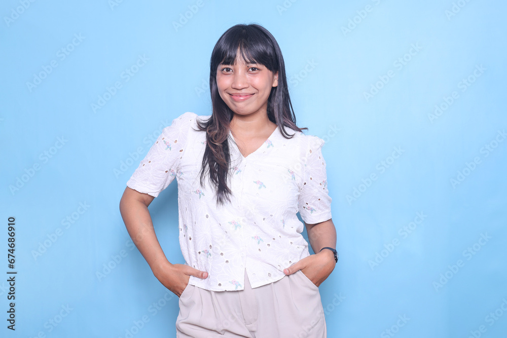 Happy Asian woman looking at camera isolated on blue background Happy Asian woman looking at camera isolated on blue background